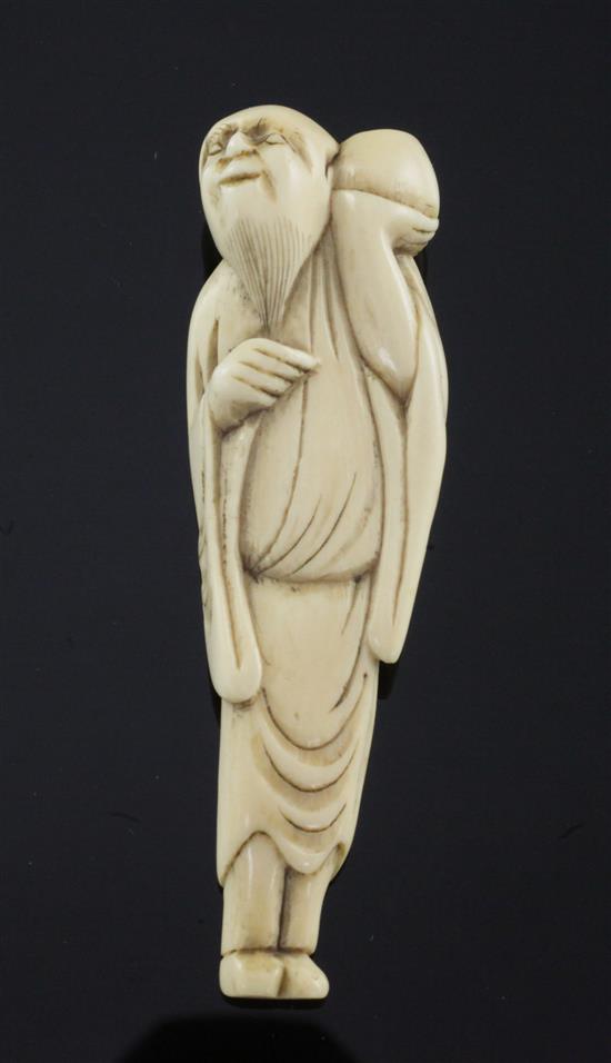 A Japanese ivory netsuke of a man holding a peach aloft, Edo period, c.1780, 7.5cm